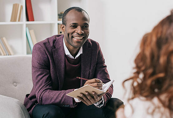 Image of a therapist speaking with a client about treatment options for substance use disorder